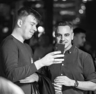 Two attendees looking at a phone during networking at SEO IRL