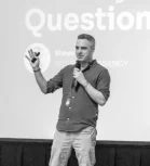 Speaker on stage in front of a presentation screen at SEO IRL